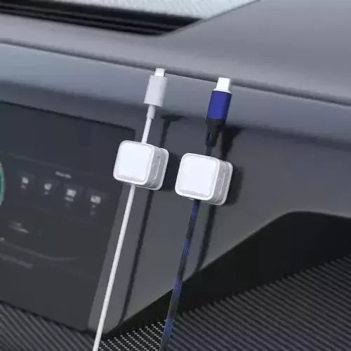 White magnetic cable clips keeping charging cables organized on a car dashboard